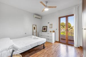 Un dormitorio blanco con una cama y una ventana. en Amazing bungalow with AC and private pool - reformado febrero 2025, en El Campello