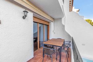Un patio con una mesa y sillas en un balcón. en Amazing bungalow with AC and private pool - reformado febrero 2025, en El Campello