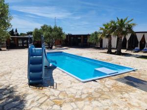a swimming pool with a slide in a yard at Mobile Home Toni with shared pool near beach in Pirovac
