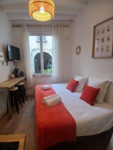 une chambre avec un grand lit blanc avec des oreillers rouges dans l'établissement STUDIO CENTRE VILLE ANGERS RDC - 2 personnes, à Angers