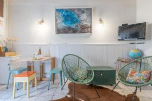 ein Zimmer mit zwei Stühlen und einem Tisch und einem Fernseher in der Unterkunft La Mirmilly - 100m de la plage in La Plaine-sur-Mer + 11 Fotos