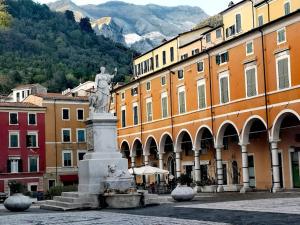 a statue in the middle of a town with buildings at Camere LaVigna in Carrara