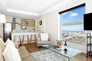 a living room with a view of a city at Blouberg Heights 1608 by Host Agents in Bloubergstrand