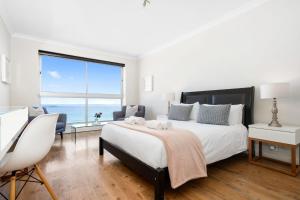 a bedroom with a large bed and a large window at Blouberg Heights 1608 by Host Agents in Bloubergstrand