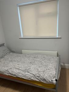 a small bed in a room with a window at Single Room in a Peaceful Area in Brent Station