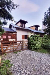 ein Haus mit einem Holzzaun davor in der Unterkunft Shelter Patagonia Hostal in El Bolsón + 36 Fotos