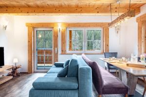 a living room with a blue couch and a table at Gästehaus zur alten Mühle in Vöhrenbach