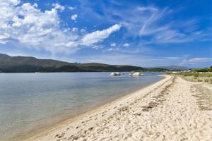 a sandy beach with boats in the water at Casa Vacanze Vista Mare-Piscina - PORTO ROTONDO in Porto Rotondo