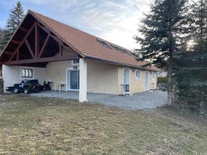 a house with a car parked in front of it at les Gites de l’E.D.E. in Saint-Léger-les-Mélèzes