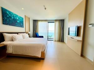 a hotel room with a bed and a flat screen tv at Seaside Skyway apartment Cam Ranh Nha Trang in Cam Lâm +28 photos