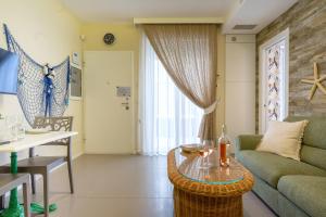 salon z kanapą i stołem w obiekcie Cozy Marine Apt with Jacuzzi - 250mt from sea w mieście Polignano a Mare