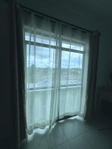 a window with white curtains in a room at Atieno home in Kwale