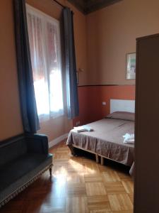 a bedroom with a bed and a window and a chair at 7 PIAZZA SANTO STEFANO Luxuryh - BOLOGNACENTRO DUOMO in Bologna