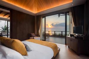 a bedroom with a bed with a view of the ocean at Saai Resort in Bang Saphan Noi