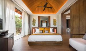 a bedroom with a bed with a ceiling fan at Saai Resort in Bang Saphan Noi