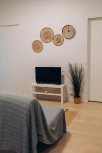 a living room with a tv and a clock on the wall at 2 bedroom apartment, parking, metro, Vantaa in Vantaa