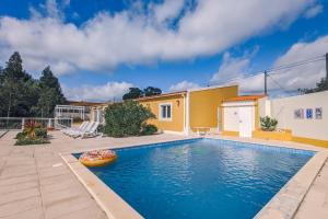 a swimming pool in a yard with a house at Casa Amarela - Countryside Villa in Alcobaça