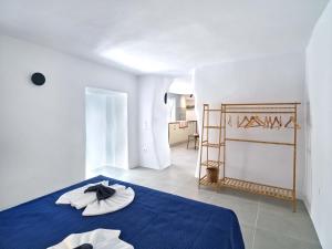 a white room with a blue bed with a blue blanket at Lefkes Blissful Home in Lefkes