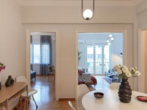 Una sala de estar y un comedor con mesa y sillas. en Acropolis view 4 bedroom flat, en Atenas