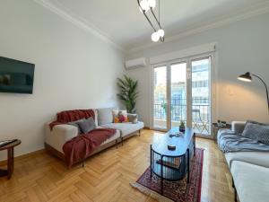una sala de estar con un sofá y una mesa en Acropolis view 4 bedroom flat, en Atenas