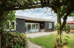 a house with a patio with blue chairs at Vakantiewoning nabij zandstrand Ouddorp VP026 in Ouddorp