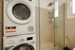 y baño con ducha y lavadora. en Acropolis view 4 bedroom flat, en Atenas 28 fotos más