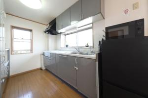 a kitchen with a sink and a black refrigerator at Villa Lotus in Kamakura