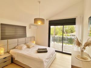 una camera da letto con un letto e una grande finestra di Villa Evasion a L'Ermitage-Les-Bains Altre 33 foto