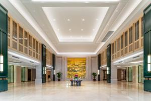 盐城建湖假日酒店的大型大堂的天花板上装饰有大型绘画作品