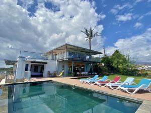 a house with a swimming pool and lounge chairs at Villa Vavangue in Saint-Gilles les Bains