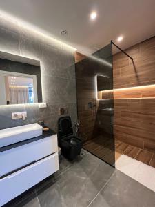 a bathroom with a black toilet and a shower at Villa Xika in Sarandë +75 photos