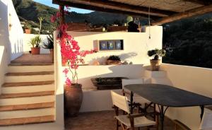 a patio with a table and a table and chairs at Casa Pomelia - in centro a Malfa in Malfa