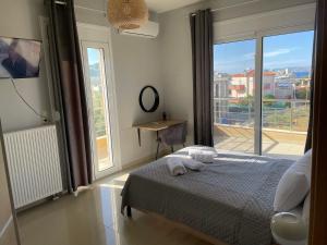 een slaapkamer met een bed en een balkon met een televisie bij Dream Villa in Kokkíni Khánion