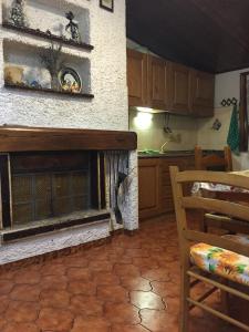 a kitchen with a fireplace in the middle of a room at Le Conifere Garden Residence in Filettino