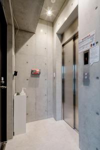 an elevator in a building with a sign on the wall at 原田屋Hotel 3F in Tokyo