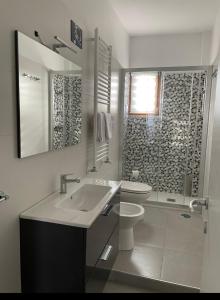 een badkamer met een wastafel, een toilet en een douche bij Terrazza Appia 112 in Potenza