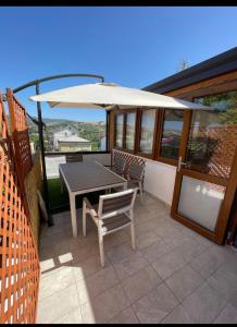 een patio met een parasol en een tafel en stoelen bij Terrazza Appia 112 in Potenza