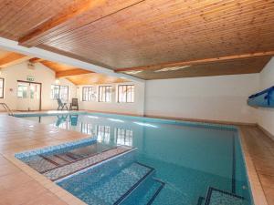 een binnenzwembad met een houten plafond bij Beaver Cottage in Thirsk