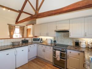 een keuken met witte kasten en witte apparaten bij Beaver Cottage in Thirsk
