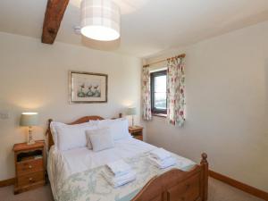 een slaapkamer met een bed met witte lakens en een raam bij Beaver Cottage in Thirsk +27 foto's