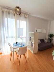 salon ze stołem, krzesłami i kanapą w obiekcie Precioso Estudio con Piscina w Maladze