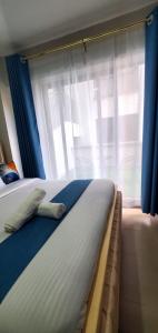 a bedroom with two beds and a window at Nyayo Haven Suites in Nairobi +1 photo