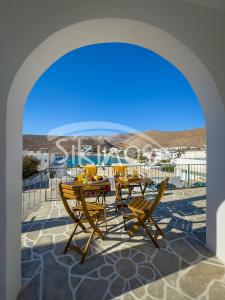 a patio with tables and chairs on a balcony at Sea View Family House in Chora Folegandros