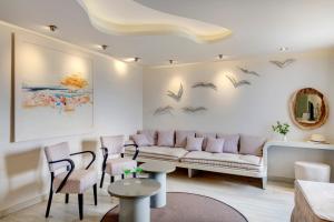 a living room with a couch and birds on the wall at Kouros Art Hotel - Designed for Adults in Stelida