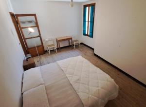 una camera da letto con un grande letto bianco in una stanza di BLACK DOLOMYTE Apartment a Schilpario