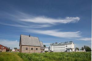 an old barn and a white building in a field at Pohjanranta Cottages in Keminmaa +24 photos
