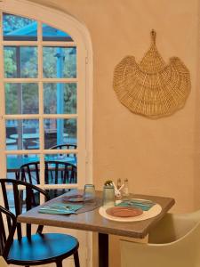 a dining room with a table and chairs and a window at Hôtel le Nid in Argelès-sur-Mer