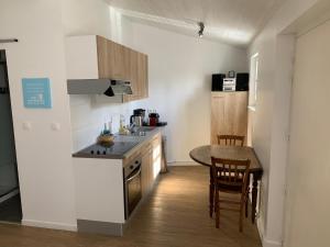 a kitchen with a counter and a table in a room at Hotel Les Bois Flottais in Le Bois-Plage-en-Ré