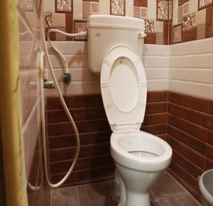 a bathroom with a toilet and a shower at Kalyan Residency By Azalea in Madurai +27 photos