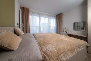 a bedroom with a bed with a large window at Eurovea Tower Apartments free Parking in Bratislava